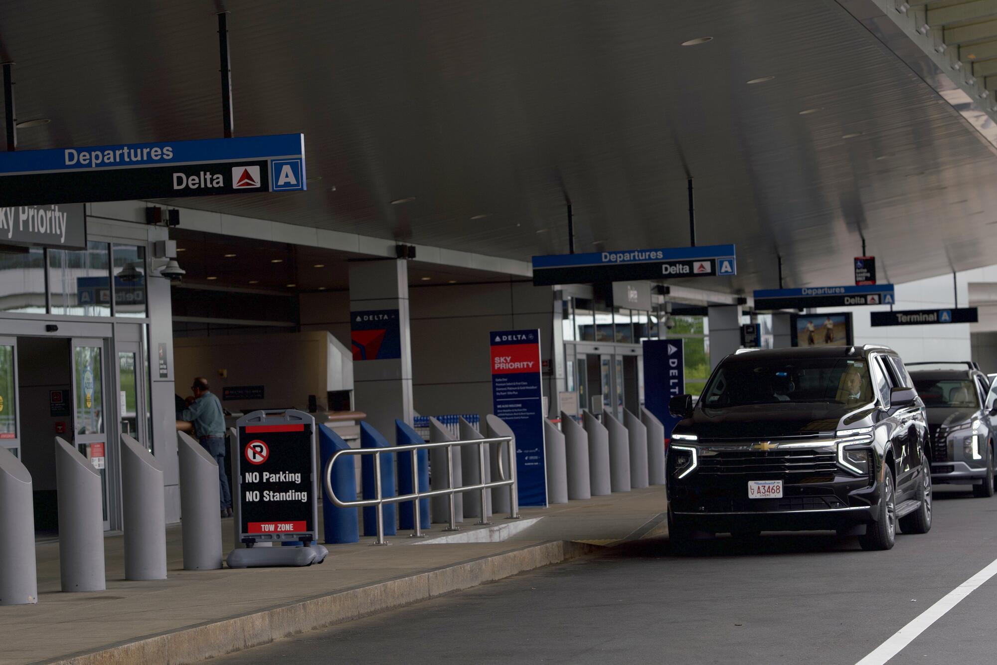 Black Chevrolet Suburban waiting at the airport departures curb
