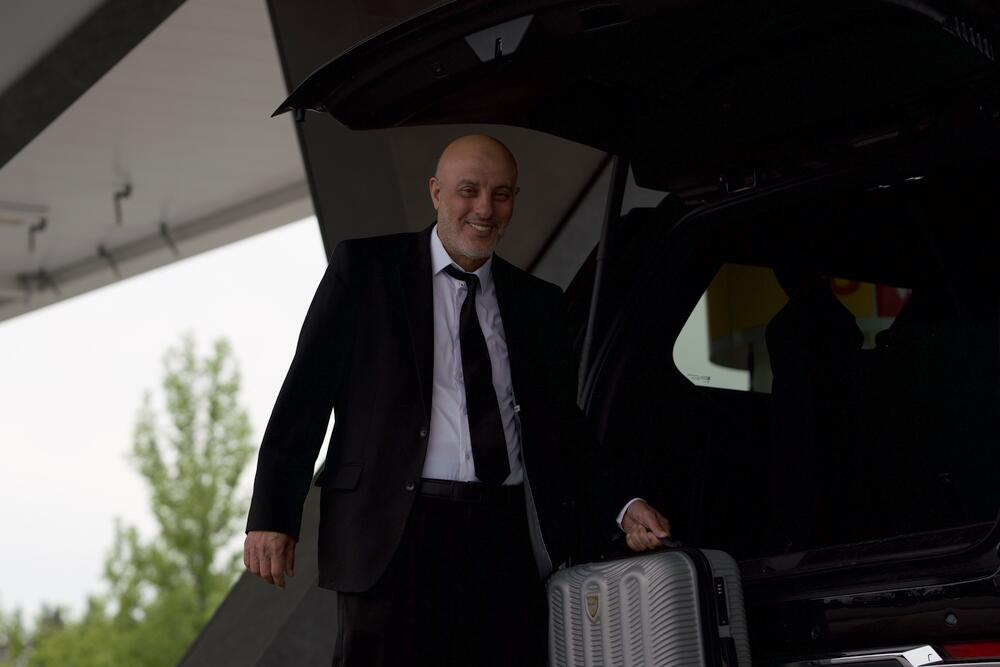 Fast Black Car chauffeur handling luggage at the airport